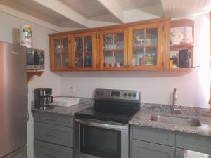 a kitchen with a sink and a stove and cabinets at Mystic Ridge Ochi in Ocho Rios
