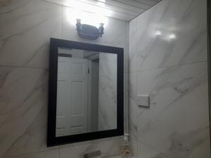 a mirror in a bathroom with white marble walls at Mystic Ridge Ochi in Ocho Rios