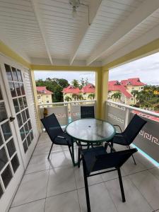 a patio with a glass table and chairs on a balcony at Mystic Ridge Ochi in Ocho Rios