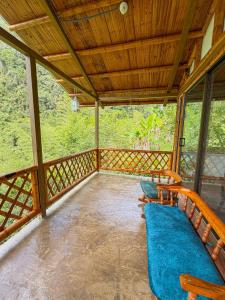 a screened in porch with chairs and a blue blanket at Cabaña ALAK in La Vega +4 photos