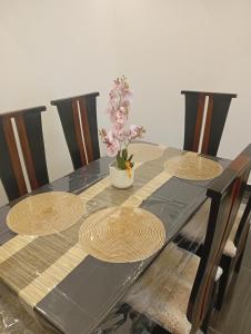 a wooden table with three plates and a potted plant on it at Résidence Prestige KGV Appt 302 in Douala +37 photos