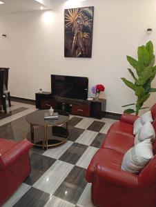 a living room with a red couch and a table at Résidence Prestige KGV Appt 302 in Douala