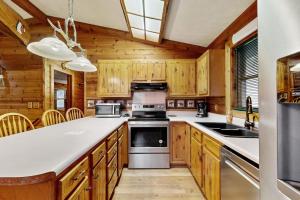 a kitchen with wooden cabinets and a stove top oven at Moose Creek Lodge in Sylva +13 photos