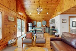 a living room with a couch and a kitchen at Happy Top Hideaway in Bryson City