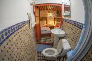a bathroom with a sink and a toilet and a mirror at Riad Fes iline Medina in Fez +80 photos