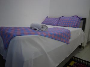 a bed with a blanket and a towel on it at Ndjuly Residencial in Luanda