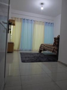 a living room with a couch and blue curtains at Ndjuly Residencial in Luanda