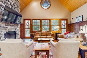 a living room with couches and a stone fireplace at Tuckaway Retreat in Sylva