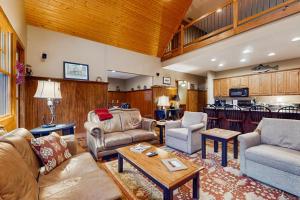 a living room with couches and chairs and a kitchen at Tuckaway Retreat in Sylva