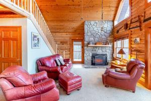 a living room with leather chairs and a stone fireplace at Cloud Walk in Sylva
