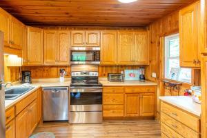 a kitchen with wooden cabinets and stainless steel appliances at The Outpost in Whittier