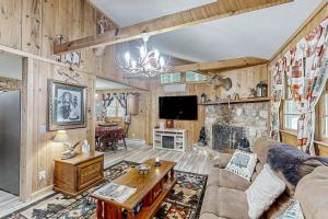 a living room with a couch and a stone fireplace at The Little Dude Cabin in Franklin