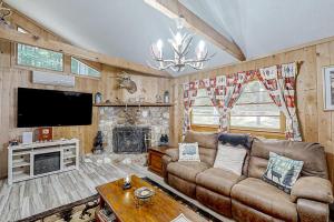 a living room with a couch and a tv at The Little Dude Cabin in Franklin