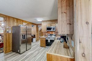 a kitchen with wooden walls and a stainless steel refrigerator at The Little Dude Cabin in Franklin +17 photos