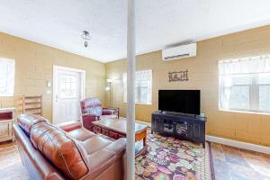 a living room with a leather couch and a television at Cozy Mountain Hideaway in Waynesville