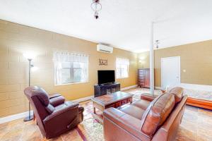 a living room with leather furniture and a bed at Cozy Mountain Hideaway in Waynesville