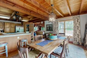 a kitchen and dining room with a wooden table and chairs at Walela Cabin in Topton +17 photos