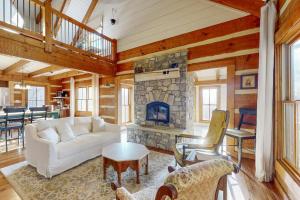 a living room with a white couch and a fireplace at Moss Creek Cabin in Sylva