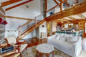 a living room with a white couch and a staircase at Moss Creek Cabin in Sylva