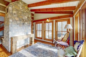 a living room with a stone fireplace in a house at Moss Creek Cabin in Sylva