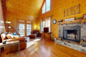 a living room with a fireplace in a log cabin at The Rushing Creek Cabin in Topton