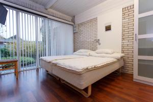 a bedroom with a bed and a large window at Give Apartment in Billund
