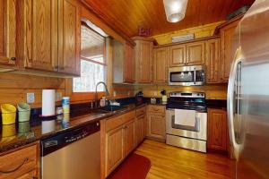 a kitchen with wooden cabinets and a stainless steel refrigerator at The Rushing Creek Cabin in Topton