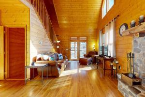a living room with a couch and a fireplace at The Rushing Creek Cabin in Topton