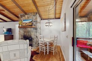 a dining room with a table and a stone fireplace at Campfire Hideaway in Highlands