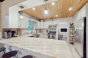 a kitchen with white cabinets and a large marble counter top at Campfire Hideaway in Highlands +16 photos