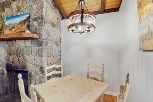 a dining room with a table and a stone fireplace at Campfire Hideaway in Highlands