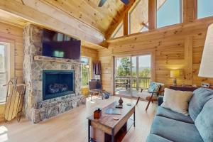 a living room with a stone fireplace in a log cabin at Nanuk in Franklin