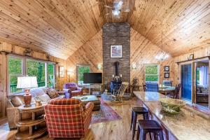 a living room with a vaulted ceiling with a fireplace at The Treehouse in Franklin