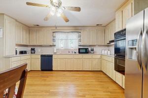 a kitchen with white cabinets and a ceiling fan at Shelba's Place in Sylva