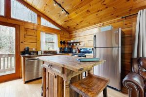 a kitchen with a refrigerator and a wooden ceiling at Creeksong Cabin in Topton