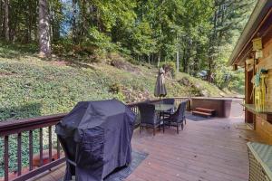 a wooden deck with a table and an umbrella at Peak and Pond Retreat in Scaly Mountain