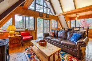 a living room with a leather couch and a table at Chalet at Peek's Creek in Franklin