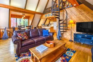 a living room with a leather couch and a tv at Chalet at Peek's Creek in Franklin