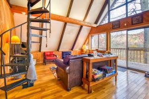 a living room with a leather couch and a spiral staircase at Chalet at Peek's Creek in Franklin +30 photos