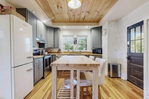 a kitchen with a wooden table and a white refrigerator at Huckleberry Hill in Waynesville +17 photos