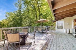 a deck with tables and chairs and an umbrella at Vista Heights Retreat in Bryson City