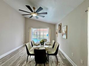 a dining room with a table and a ceiling fan at Modern 4BR2BA with pool in gated community in Kissimmee