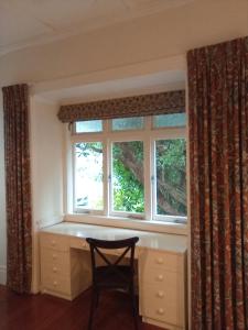 a chair sitting in front of a window at School Lane Guesthouse in Whangarei +5 photos