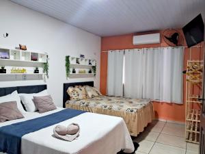 two beds in a room with orange walls at Hospedagem Aconchego Do Lar in Barreirinhas