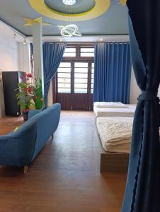 a bedroom with two beds and a blue curtain at QN Home in Quy Nhon