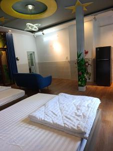 a bedroom with two beds and a blue chair at QN Home in Quy Nhon +27 photos