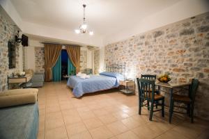 Schlafzimmer mit einem Bett, einem Tisch und Stühlen in der Unterkunft Vathi Hotel in Vathy
