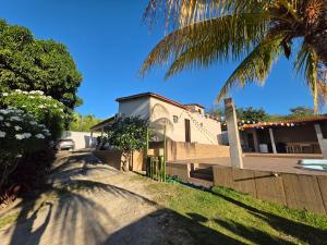 a house with a fence and a palm tree at Mirante in Crato