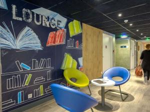 a room with blue and yellow chairs and a table at ibis budget Brignoles Provence in Brignoles +36 photos