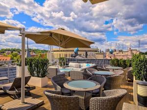 a patio with tables and chairs and an umbrella at Mercure Bydgoszcz Sepia in Bydgoszcz